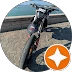 Simons Garage - Fahrzeugaufbereitung - Ein elektrisches Dirtbike steht auf einem asphaltierten Weg.